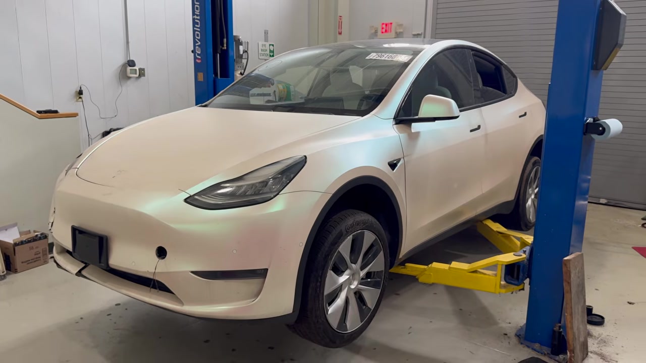 White 2020 Tesla Model Y on a two-post lift in the WattWorks shop