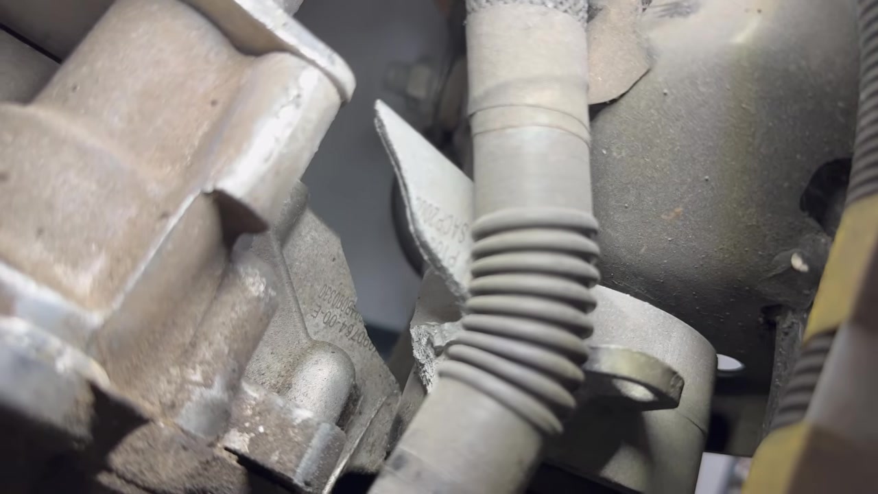 Close-up of a Model Y rear drive unit motor mount sheared through the cast housing