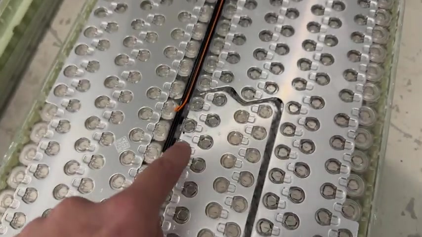 Close-up of a Model S module collector plate with the orange voltage sense lead that is not connected to the plate